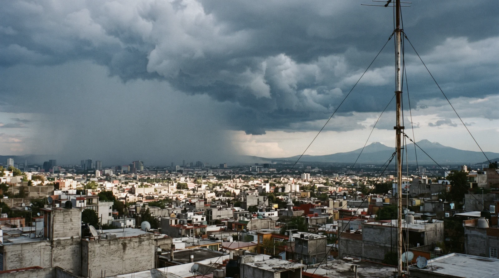 Afternoon storm clouds building over the valley behind the city skyline, the rainy season in Mexico City