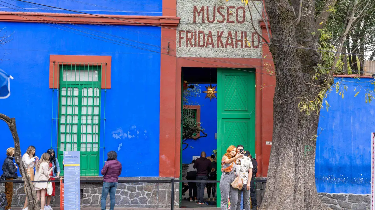 Visitors in the cobalt-blue courtyard of the Casa Azul on a Frida Kahlo Museum entry ticket in Coyoacán, Mexico City