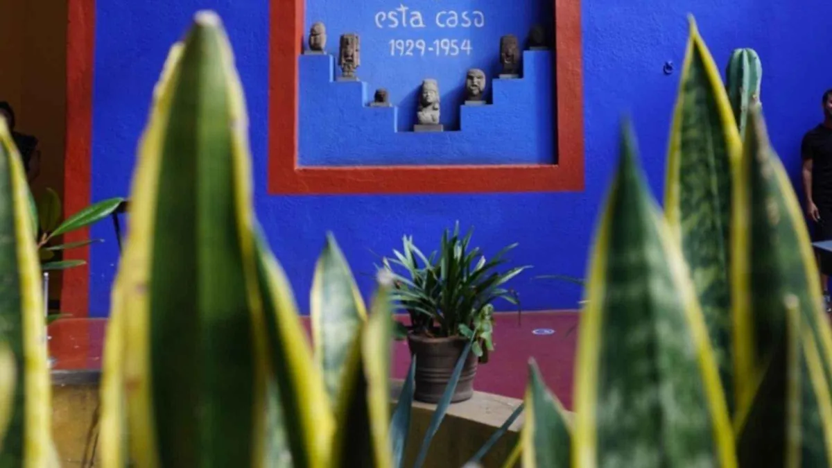 A guide talking to a small group beside Frida Kahlo's studio window at the Casa Azul, Mexico City