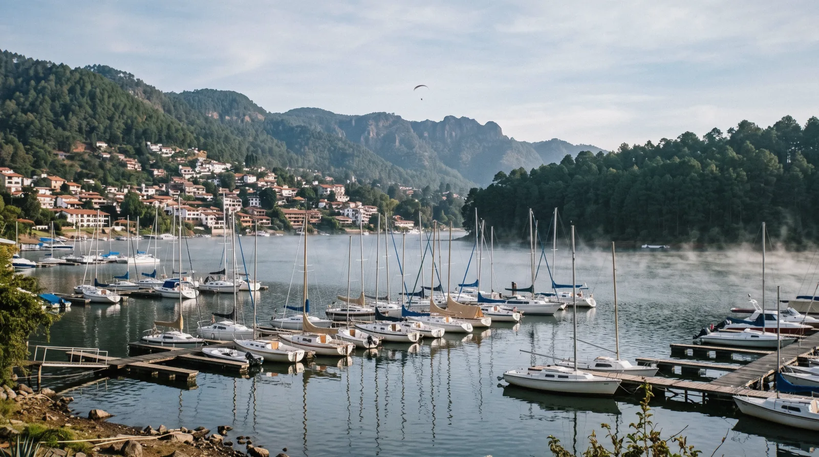 Sailing boats on the lake below the red roofs of Valle de Bravo, a weekend trip from Mexico City